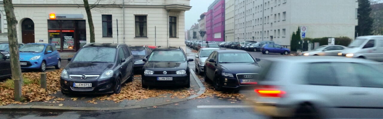 Auto fährt an parkenden Autos vorbei