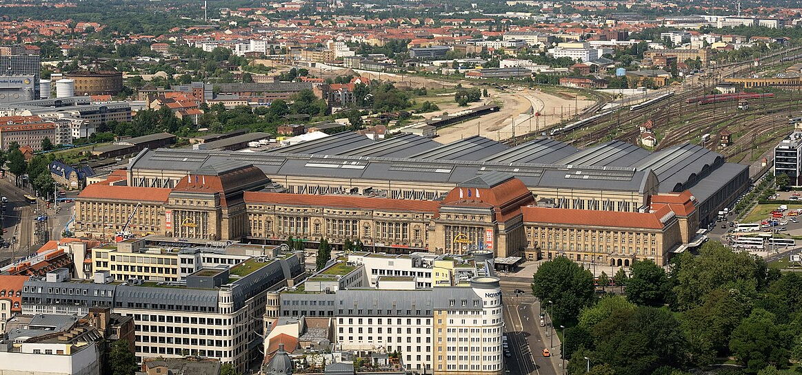 Schrägluftbild vom Leipziger Hauptbahnhof mit Blick nach Norden. Im Vordergrund das Bahnhofsgebäude im Hintergrund das Gleisvorfeld.