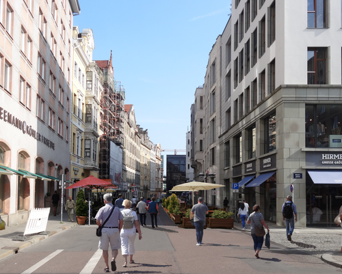 Katharinenstraße in Leipziger Innenstadt mit vielen Fußgängern und einem begrüntem Freisitz mit Sonnenschirm