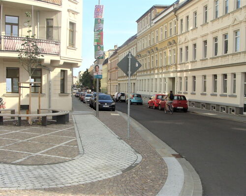 neu gestalteter Kreuzungsbereich zwischen Gießerstraße und Rolf-Axen-Straße mit Straßenbau, Sitzbank und aufwendigem Gehwegpflaster