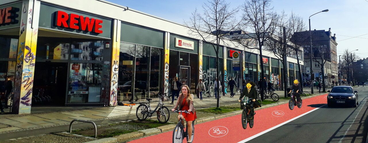 Radfahrer:innen auf rotem Radweg vor einem REWE-Supermarkt