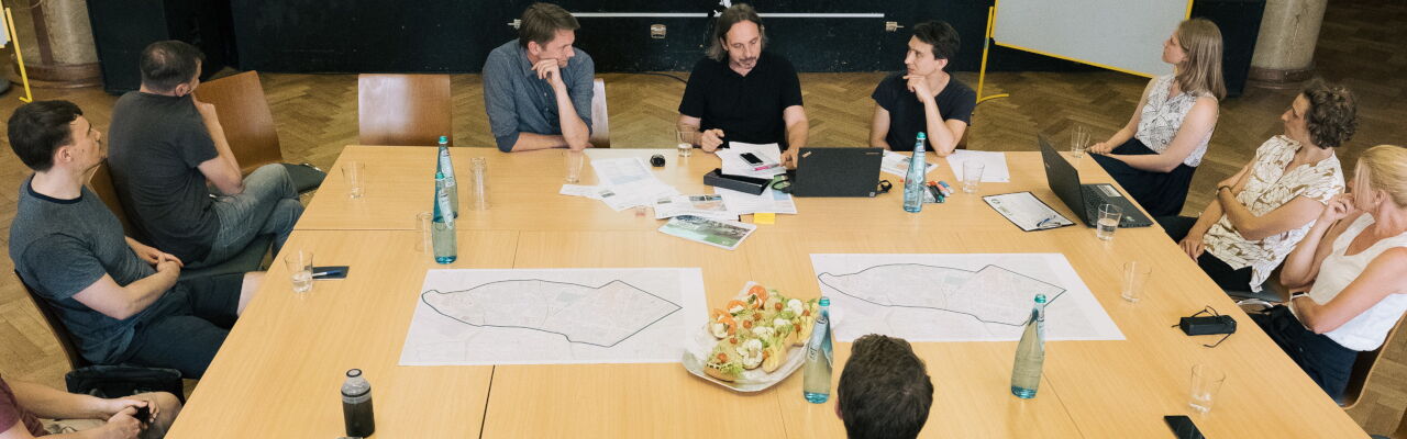 Menschen sitzen an einem Tisch und diskutieren