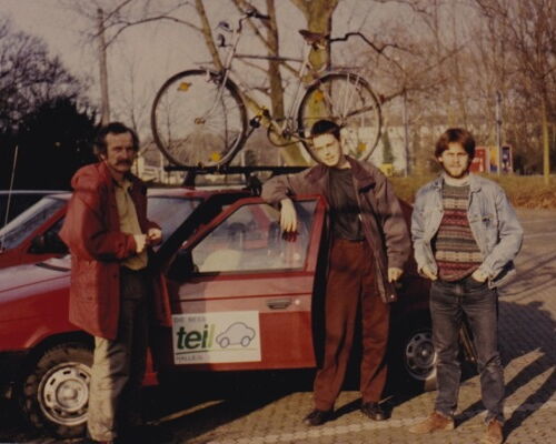 Erstes teilAuto, ein Skoda Favorit. Die Initiatoren stehen um das Auto herum, ein Fahrrad ist auf dem Dach des Autos befestigt