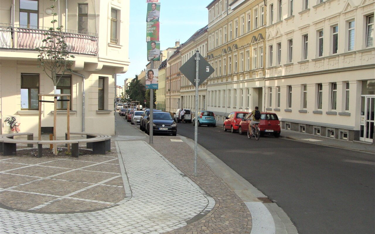 neu gestalteter Kreuzungsbereich zwischen Gießerstraße und Rolf-Axen-Straße mit Straßenbau, Sitzbank und aufwendigem Gehwegpflaster