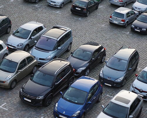 Autos auf Parkplatz mit Pflastersteinen