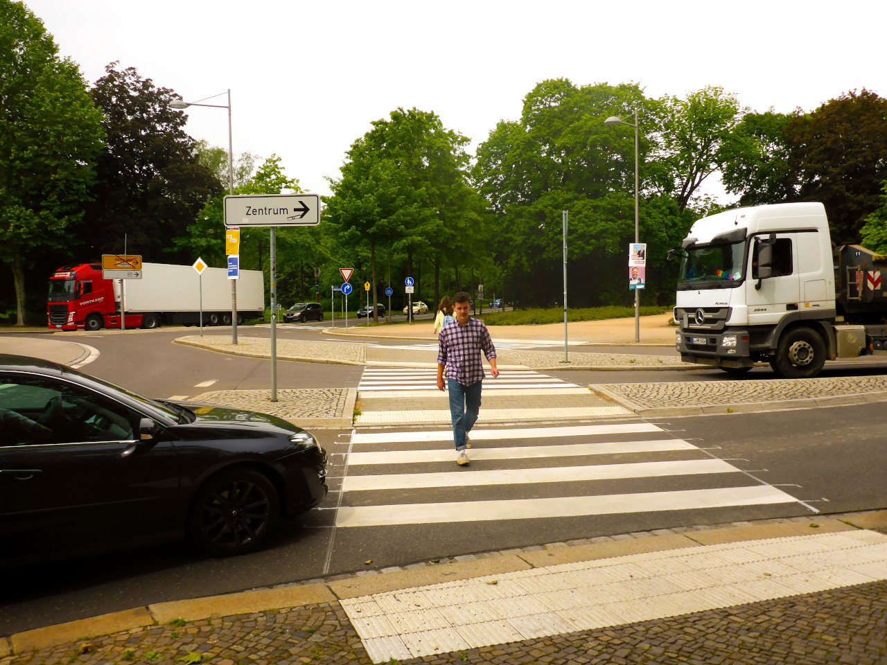 Mann geht über einen Zebrastreifen