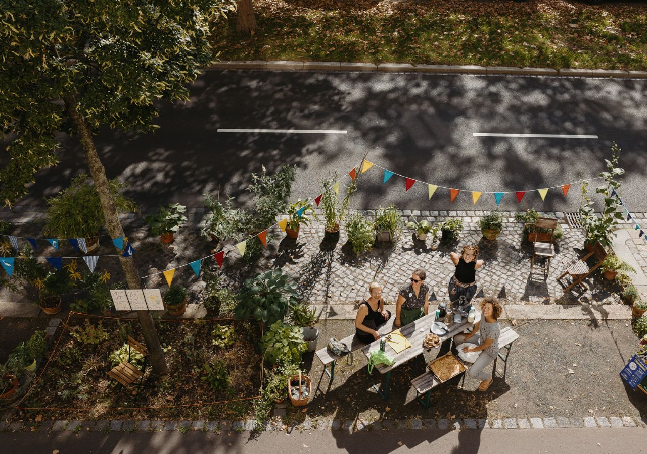 Gemeinsam gestalten Menschen während des Park(ing) Day eine Parklücke zu einem kleinen Park um.