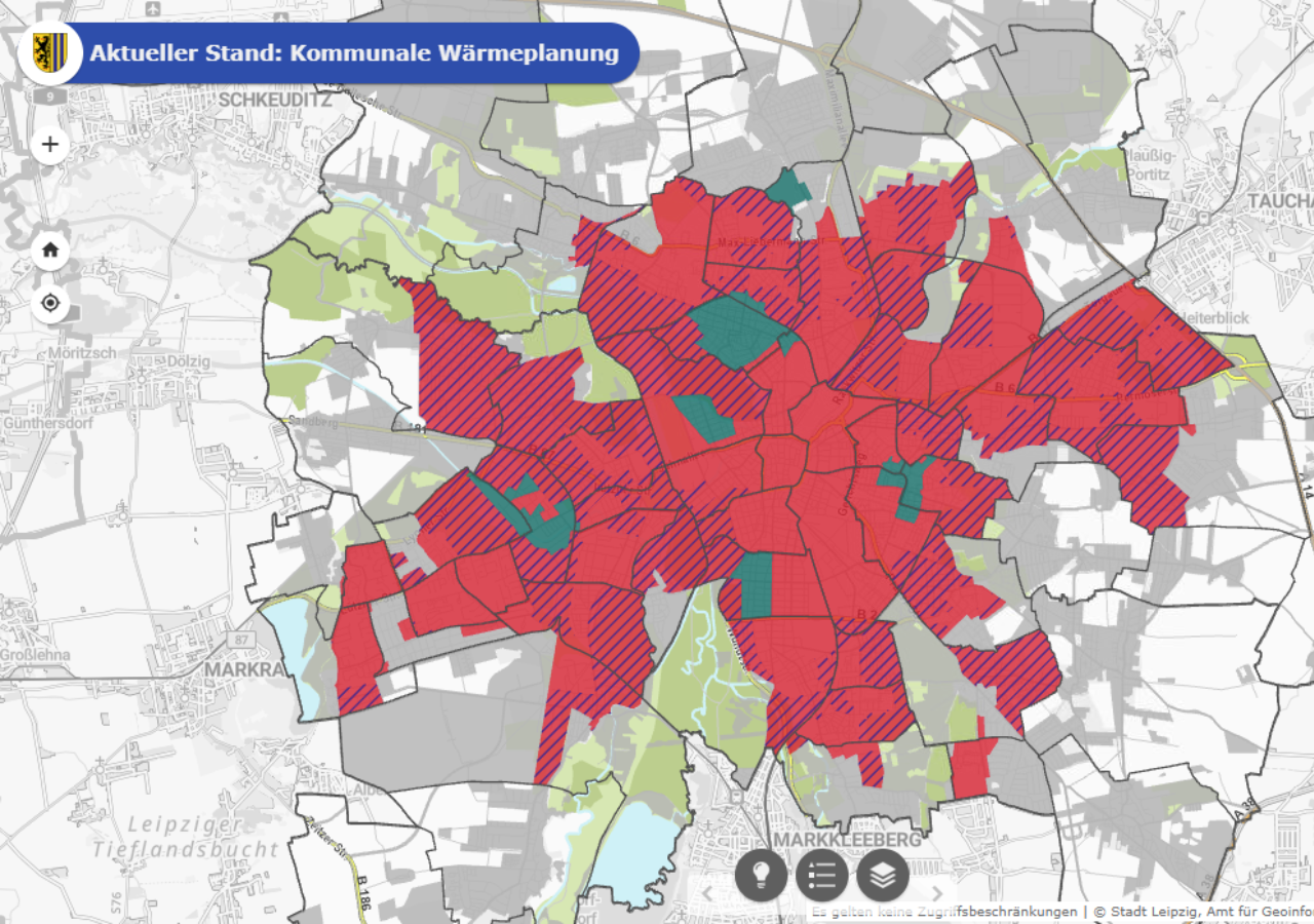 Karte von Leipzig mit farblich markierten Gebieten zur kommunalen Wärmeplanung, rote Flächen mit schwarzen Schraffuren, grüne und graue Bereiche.