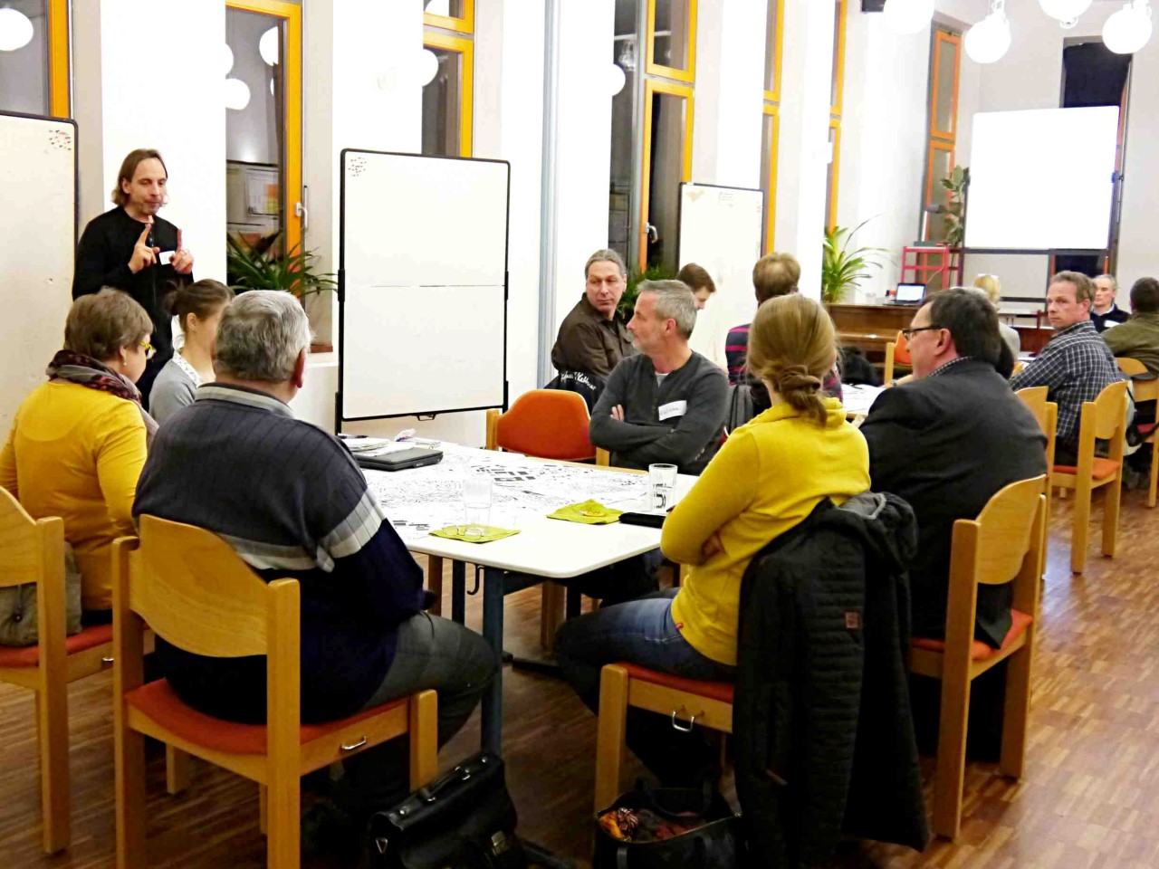 Menschen sitzen um einen Tisch mit Kartenmaterial