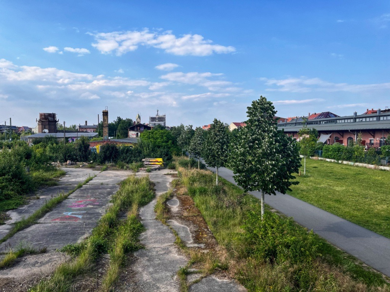Fläche des Bürgerbahnhof Plagwitz erhöhter Blick aus südlicher Richtung. Im Vordergrund die Betonplatte mit Bewuchs und im Hintergrund die ruinösen Bahngebäude